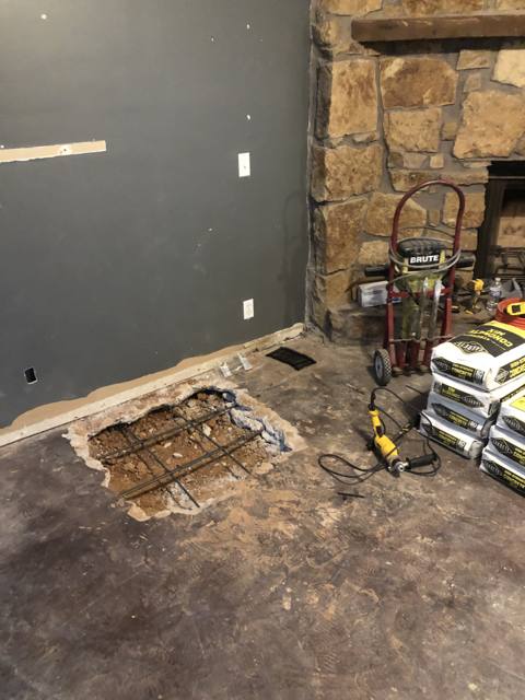 Slab before: floor cut open and trenched, rebar exposed
