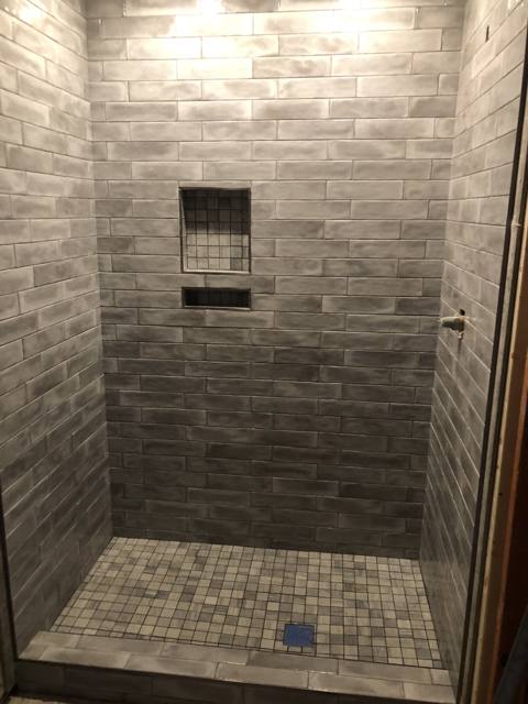 Custom tiled shower with inset niche and mosaic accent