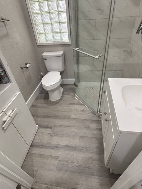 Bathroom after: finished bath with new floor, vanity, and glass-block window