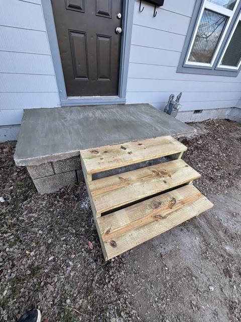 Front steps after: freshly poured concrete stoop with new wood steps
