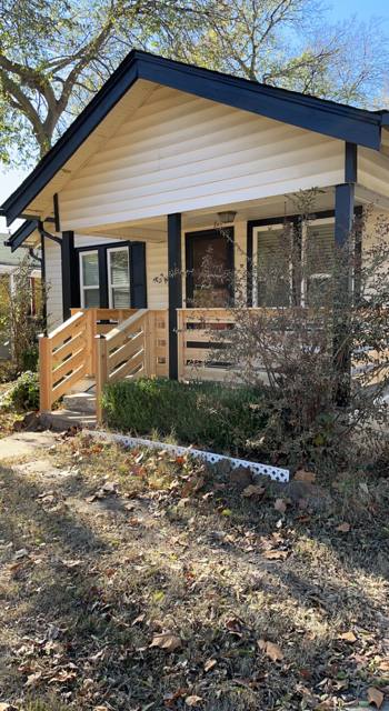 House exterior with rebuilt front porch and new wood railings