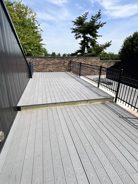 New composite deck with black metal railing and privacy wall