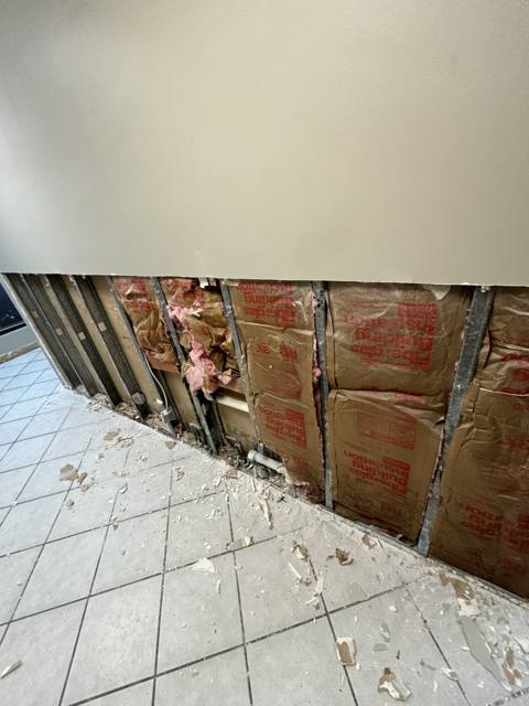 Commercial wall during: insulation and framing exposed overhead